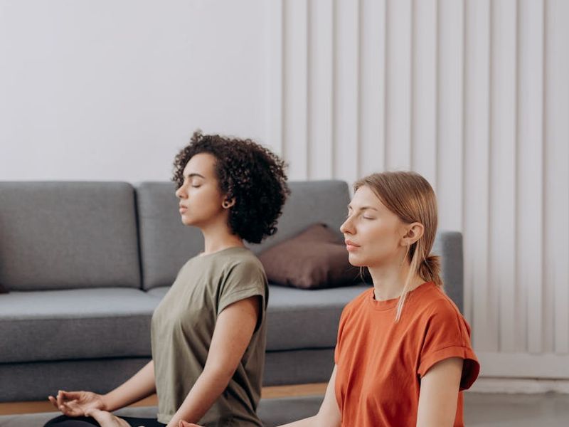 Person holding a focused yoga pose in a minimalist room.